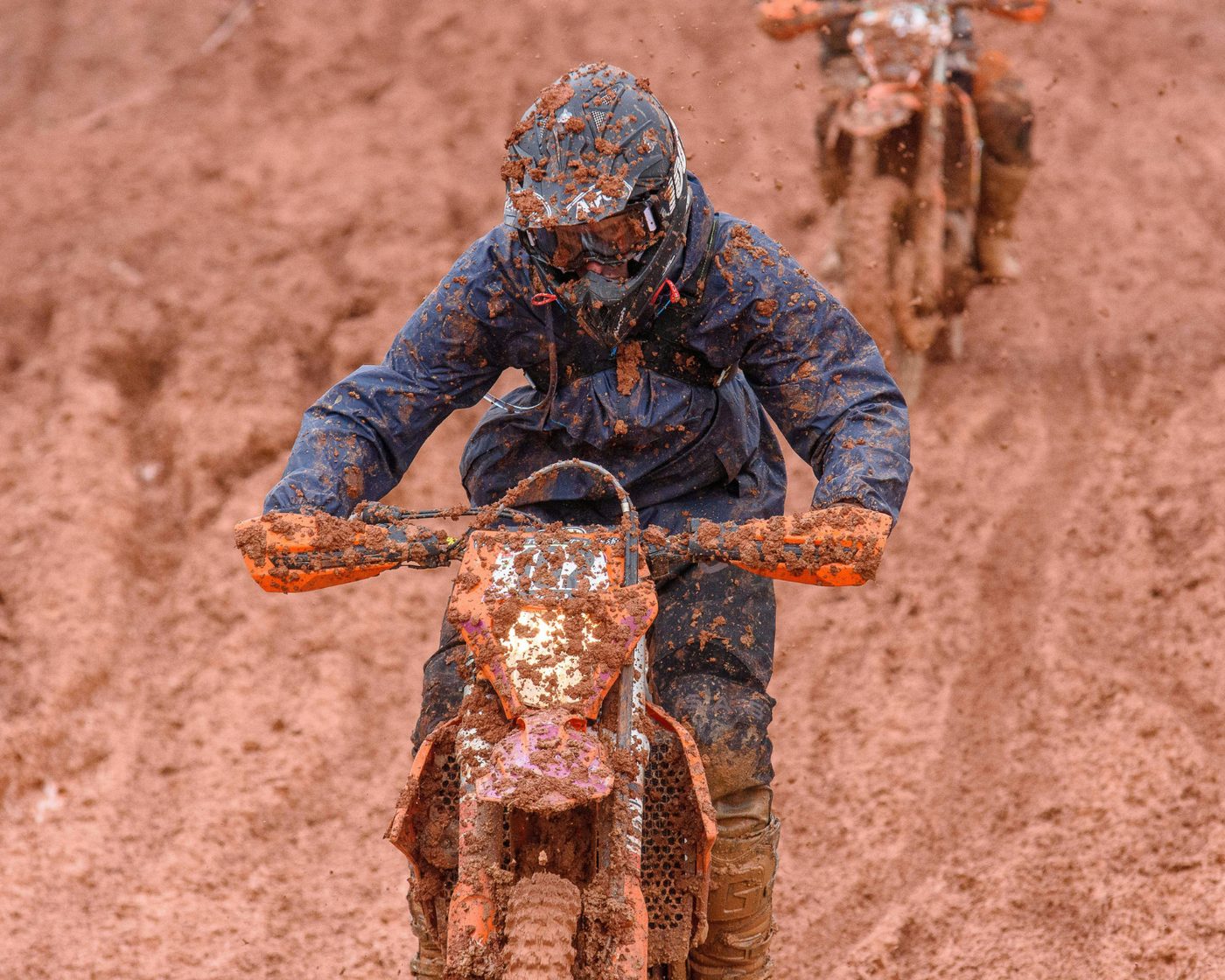 Rider covered in mud — authentic moto camp moment